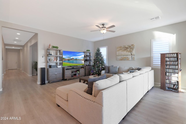 living room with a ceiling fan, baseboards, visible vents, and light wood-type flooring