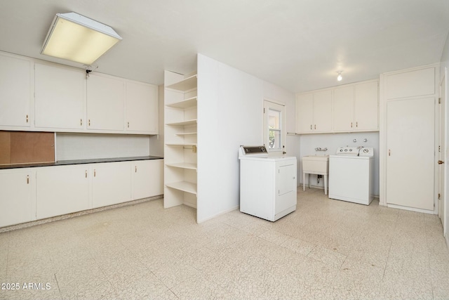 washroom featuring cabinets, sink, and washing machine and clothes dryer