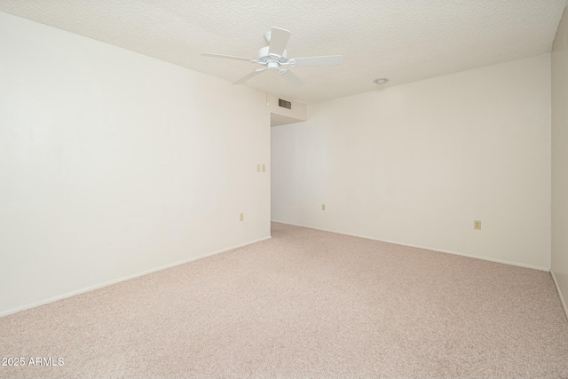 carpeted spare room with a textured ceiling and ceiling fan