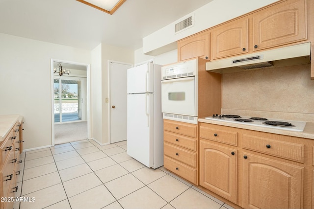 kitchen with a notable chandelier, light brown cabinets, light tile patterned flooring, and white appliances