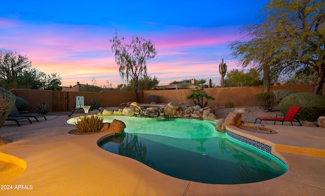 pool at dusk featuring a patio area