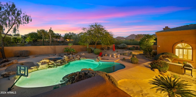 pool at dusk featuring a patio area