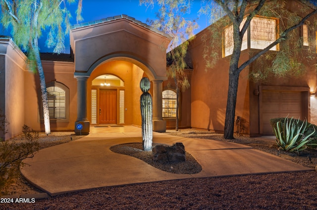 exterior entry at dusk with a garage