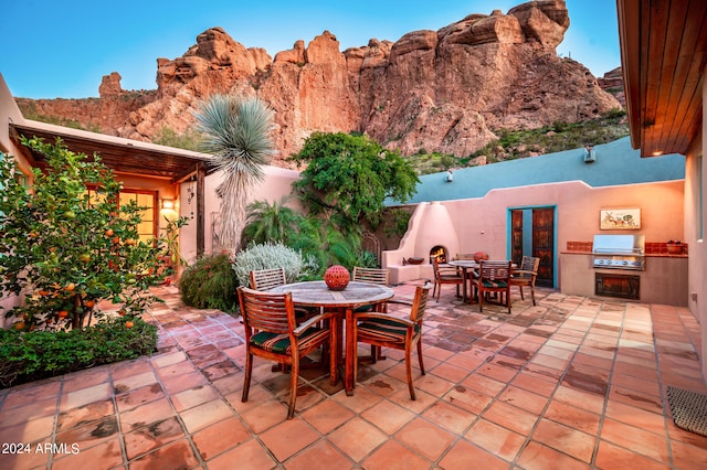 view of patio featuring a mountain view, area for grilling, and an outdoor kitchen