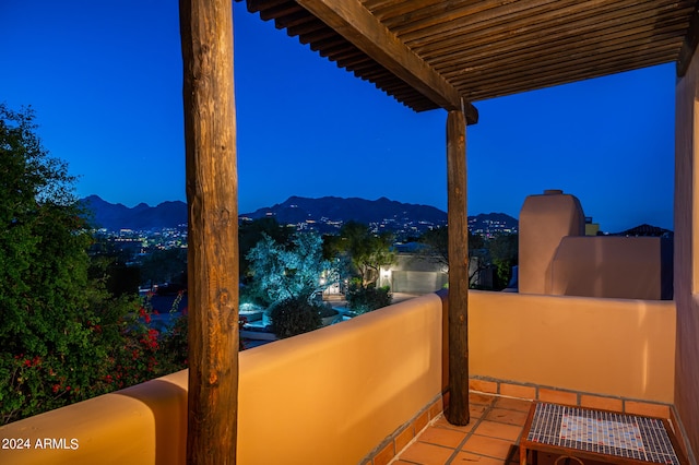 patio terrace at twilight featuring a mountain view