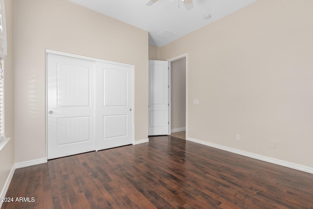 unfurnished bedroom featuring dark wood-type flooring, ceiling fan, and a closet