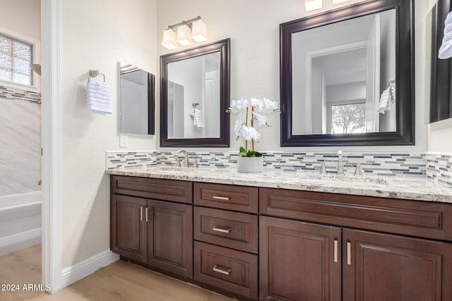 bathroom with vanity, hardwood / wood-style flooring, and backsplash