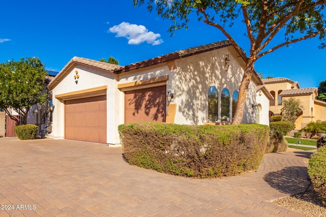 mediterranean / spanish home featuring a garage