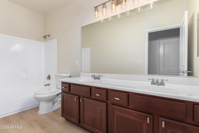 full bathroom with vanity, hardwood / wood-style flooring, toilet, and  shower combination