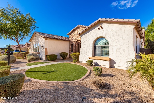 mediterranean / spanish house with a front lawn