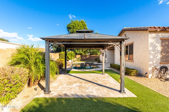 view of patio / terrace with a gazebo and a swimming pool with hot tub