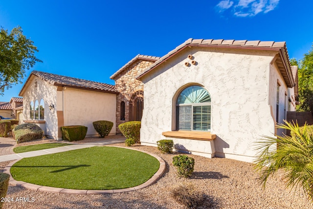 mediterranean / spanish house with a front lawn