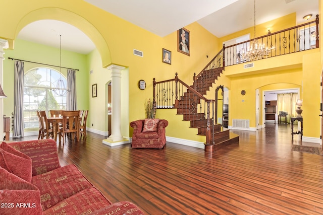living room with arched walkways, an inviting chandelier, and visible vents