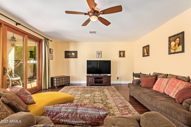 living area featuring visible vents, baseboards, ceiling fan, and wood finished floors