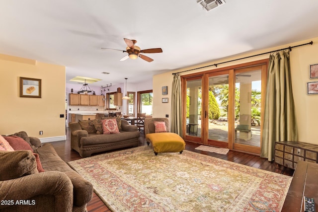 living area featuring baseboards, a ceiling fan, dark wood-type flooring, and visible vents