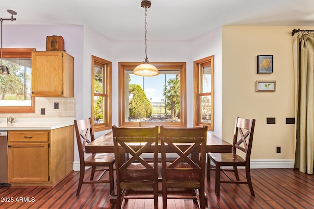 dining area with dark wood-type flooring, baseboards, and a wealth of natural light