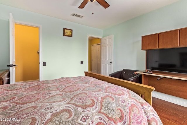 bedroom featuring visible vents, a ceiling fan, and wood finished floors