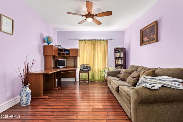 living area with a ceiling fan, baseboards, and dark wood-type flooring