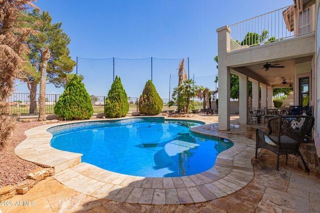 view of swimming pool with a patio, ceiling fan, fence, and a fenced in pool