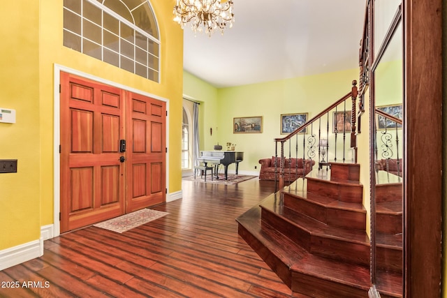 entryway featuring stairway, baseboards, dark wood-type flooring, and a notable chandelier