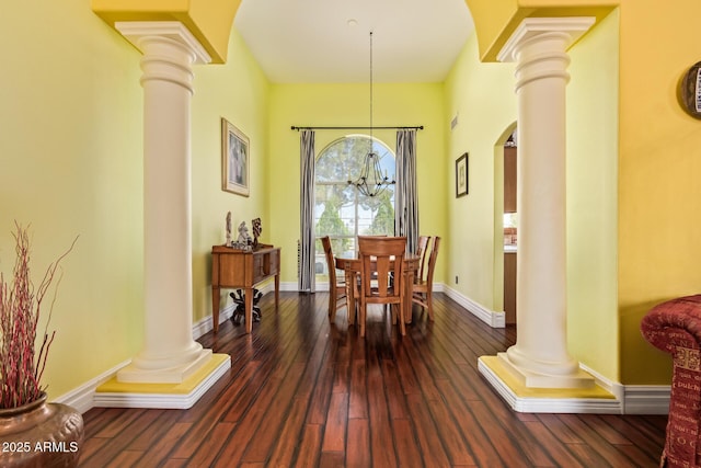 dining space featuring ornate columns, a chandelier, and hardwood / wood-style flooring