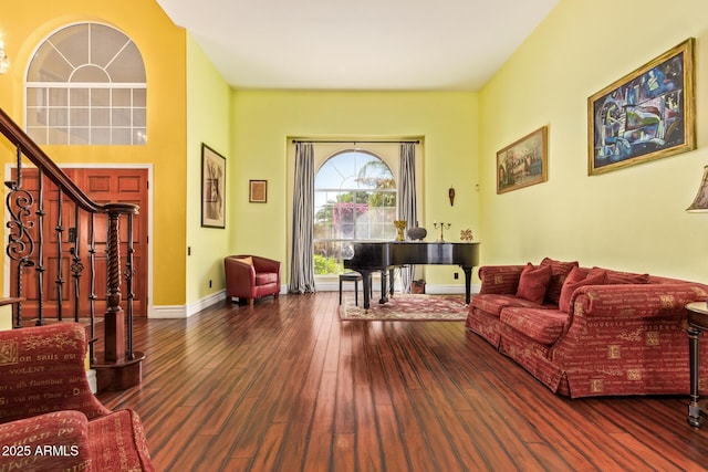 living room with baseboards, hardwood / wood-style flooring, and stairs