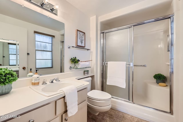 bathroom with vanity, toilet, and a stall shower