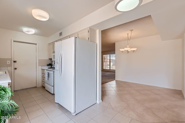 kitchen featuring white appliances, a notable chandelier, light countertops, and visible vents