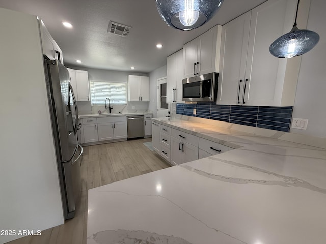 855 S Revolta Cir, Mesa, AZ 85208 - kitchen featuring visible vents, a sink, backsplash, stainless steel appliances, and white cabinets