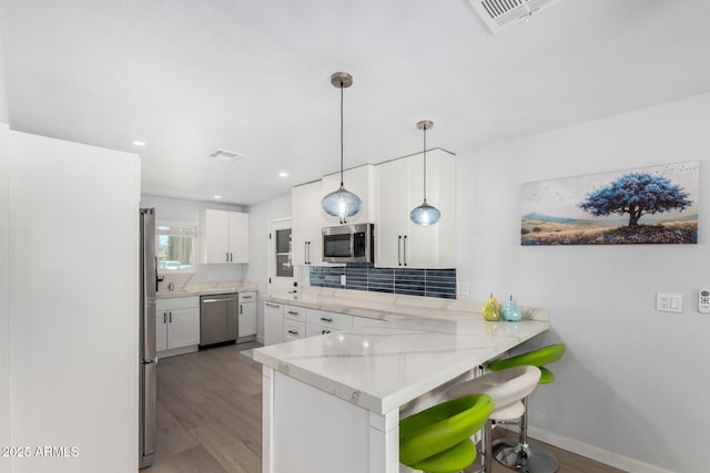 855 S Revolta Cir, Mesa, AZ 85208 - kitchen featuring a peninsula, light wood-type flooring, stainless steel appliances, and visible vents