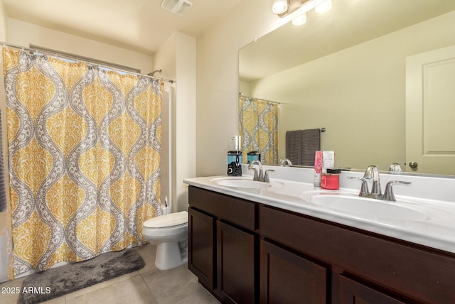 bathroom featuring vanity, tile patterned floors, and toilet