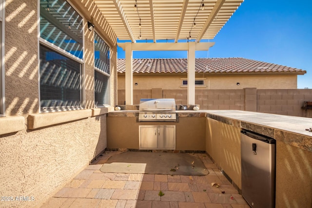 view of patio / terrace with area for grilling, a pergola, and an outdoor kitchen