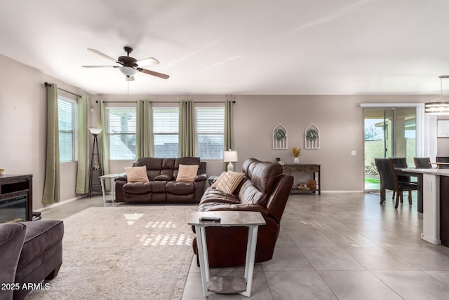 living room with a wealth of natural light, ceiling fan, and light tile patterned floors