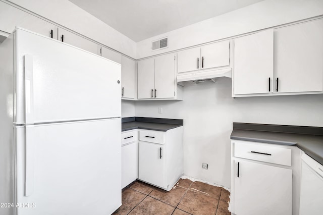 kitchen with white cabinetry, tile patterned flooring, and white fridge