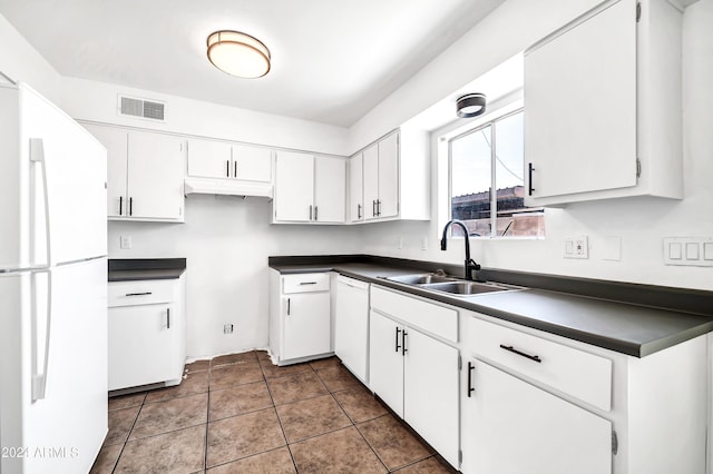 kitchen featuring dark tile patterned flooring, white appliances, white cabinetry, and sink