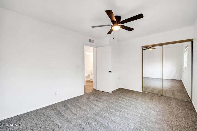 unfurnished bedroom featuring ceiling fan, light colored carpet, and a closet