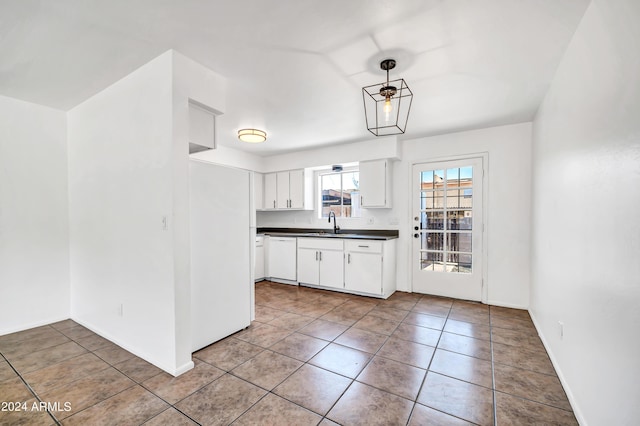 kitchen with white cabinetry, dishwasher, sink, pendant lighting, and light tile patterned floors