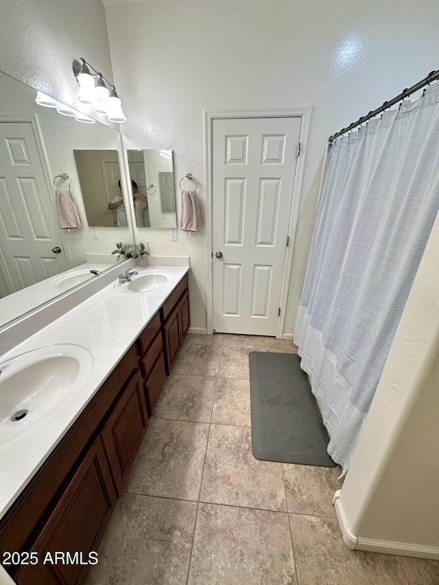 full bath with double vanity, a sink, and tile patterned flooring
