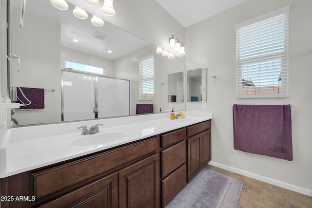 full bath with visible vents, a sink, double vanity, and a shower stall