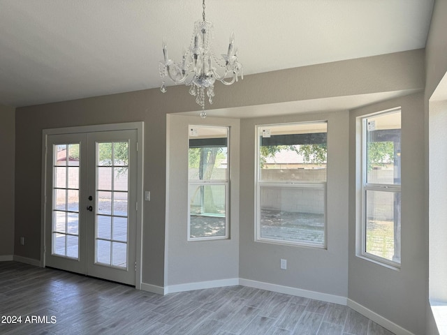 doorway to outside featuring hardwood / wood-style flooring, a notable chandelier, and french doors