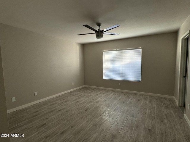 unfurnished room featuring ceiling fan and dark wood-type flooring