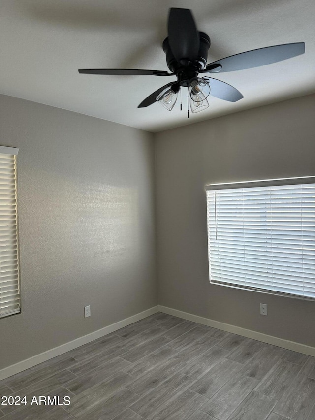 empty room with ceiling fan and hardwood / wood-style flooring