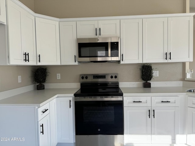 kitchen with appliances with stainless steel finishes and white cabinetry