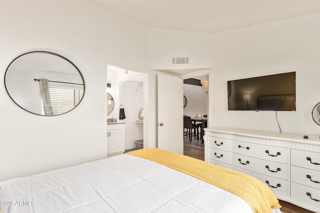 bedroom featuring dark wood-style floors, connected bathroom, and visible vents