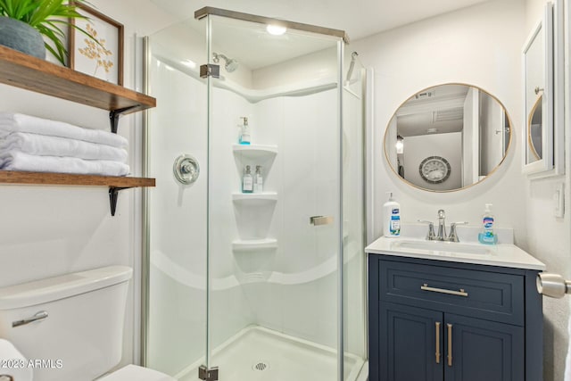 bathroom with a stall shower, vanity, and toilet