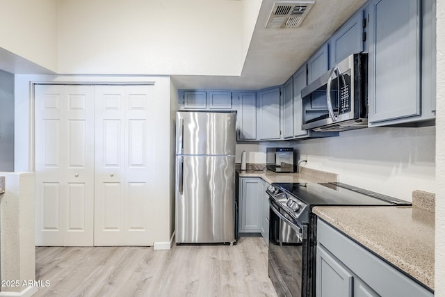 1331 W Baseline Rd Unit 360, Mesa, AZ 85202 - kitchen with appliances with stainless steel finishes, light wood-style flooring, light countertops, and blue cabinets