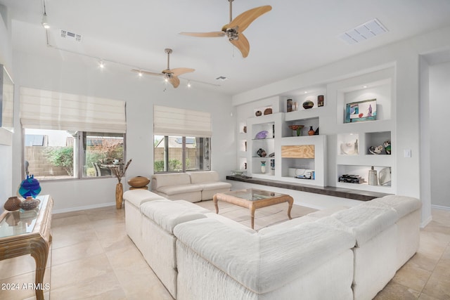 tiled living room featuring built in shelves, rail lighting, and ceiling fan