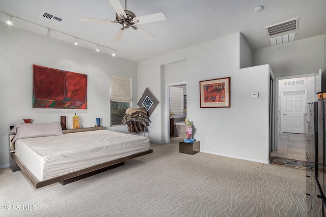 bedroom featuring track lighting, ceiling fan, light colored carpet, and ensuite bathroom