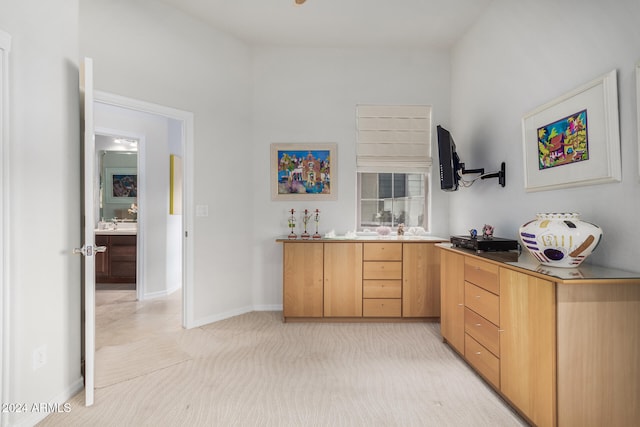 bar with light brown cabinetry and light colored carpet