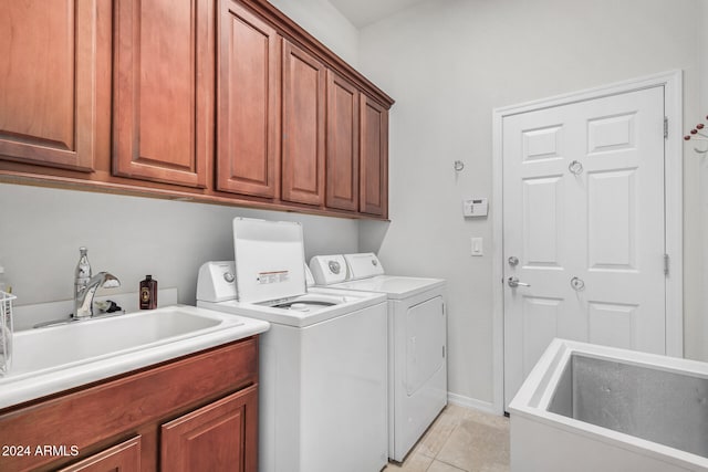 washroom featuring cabinets, light tile patterned floors, sink, and washing machine and clothes dryer